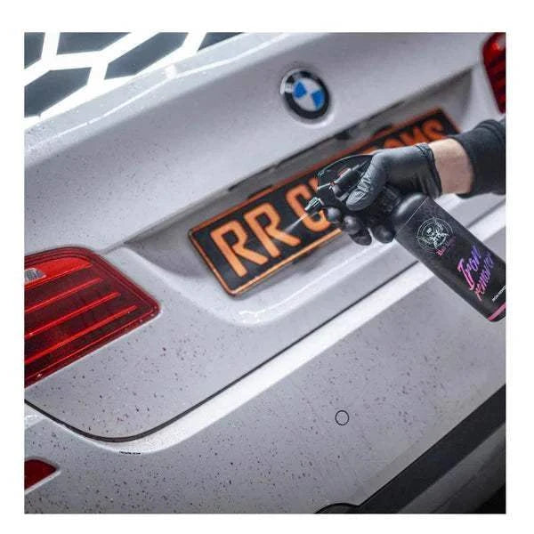 Odstranjivač željezne kontaminacije u crnoj bočici s ljubičastim natpisom nanosi se na bijeli automobil
