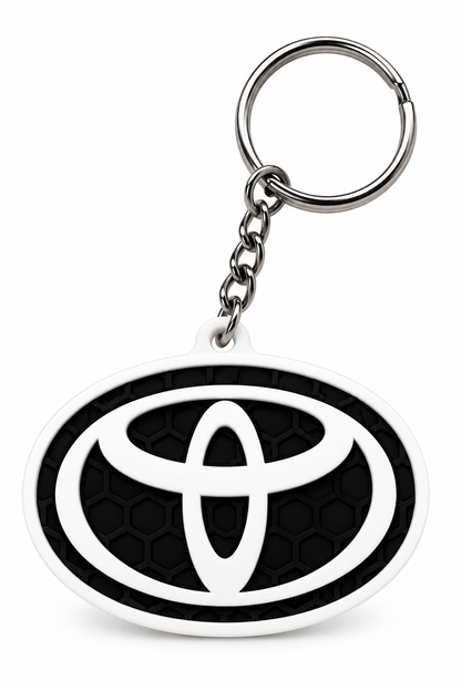 Privjesak za ključeve s crnim reljefnim uzorkom saća, bijelim ovalnim rubom i istaknutim Toyota logotipom